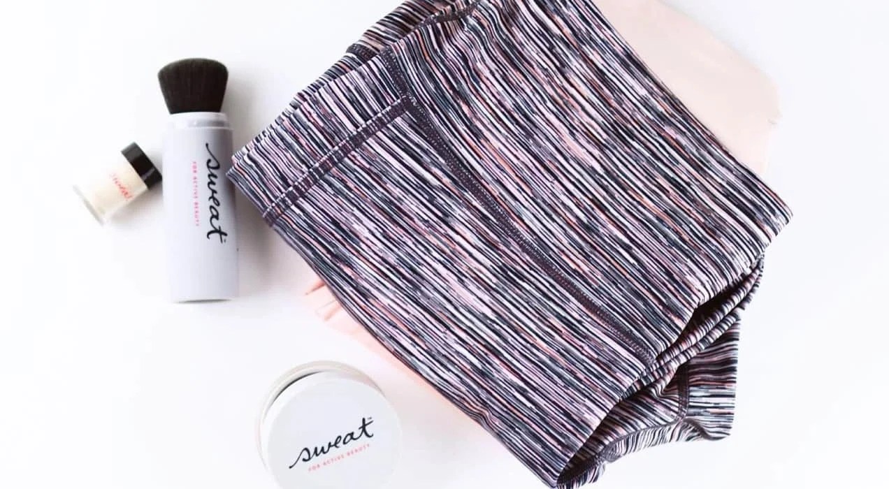 workout clothes and makeup in a pile